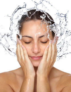 Une femme utilise de l'eau comme cosmétique