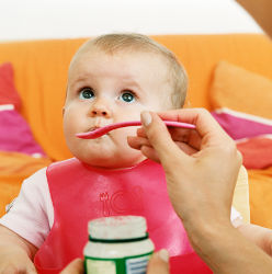 Bébé qui mange un pot de cacahuètes