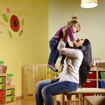 Professionnelle de la petite enfance avec une petite fille en crèche